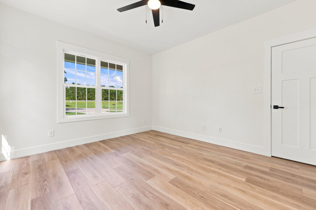 Primary Bedroom — Natural light, durable flooring, and a front-facing window