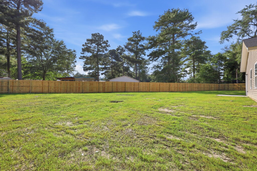 Open Outdoor Space — Mature trees and a broad lawn give the property privacy and breathing room