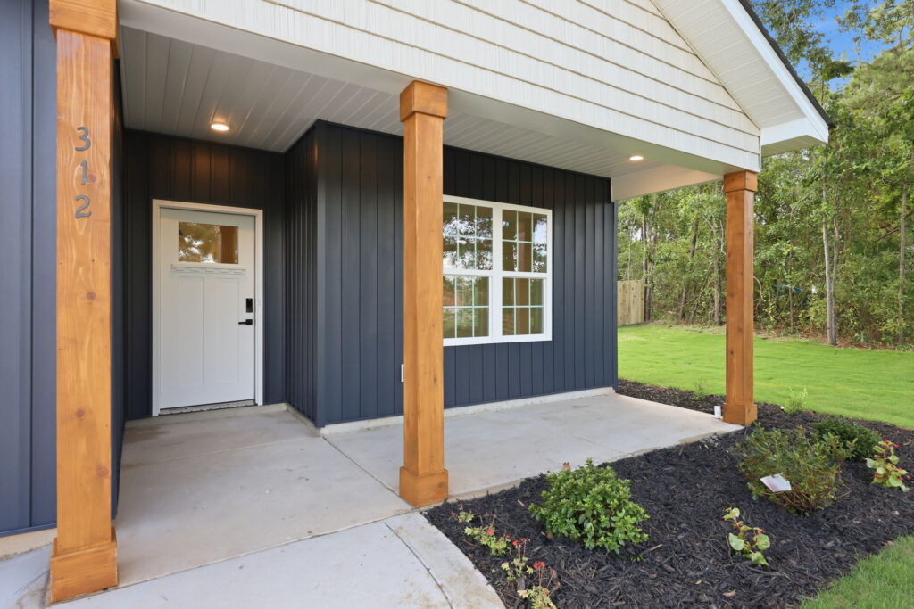 Cedar-Tone Porch Posts — Cedar-tone porch posts frame the entry against deep blue siding